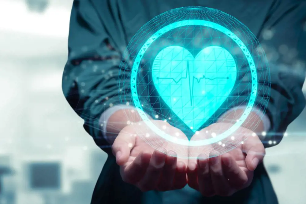 En person som holder et hologram av et hjerte, inni hjertet er det en ekg-kurve.