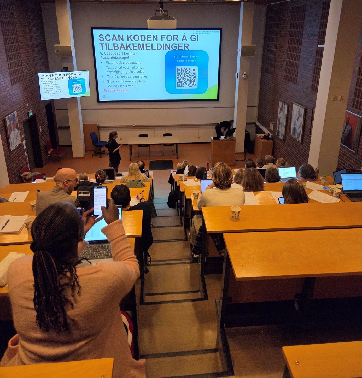 En person som holder en presentasjon for en gruppe mennesker