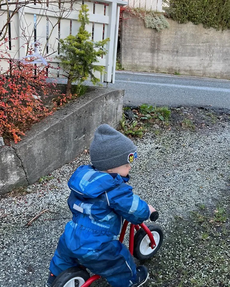 Et barn som sykler på trehjulssykkel