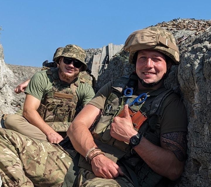 Serhii Pashkovskyi og en annen soldat sitter og ser mot kamera.