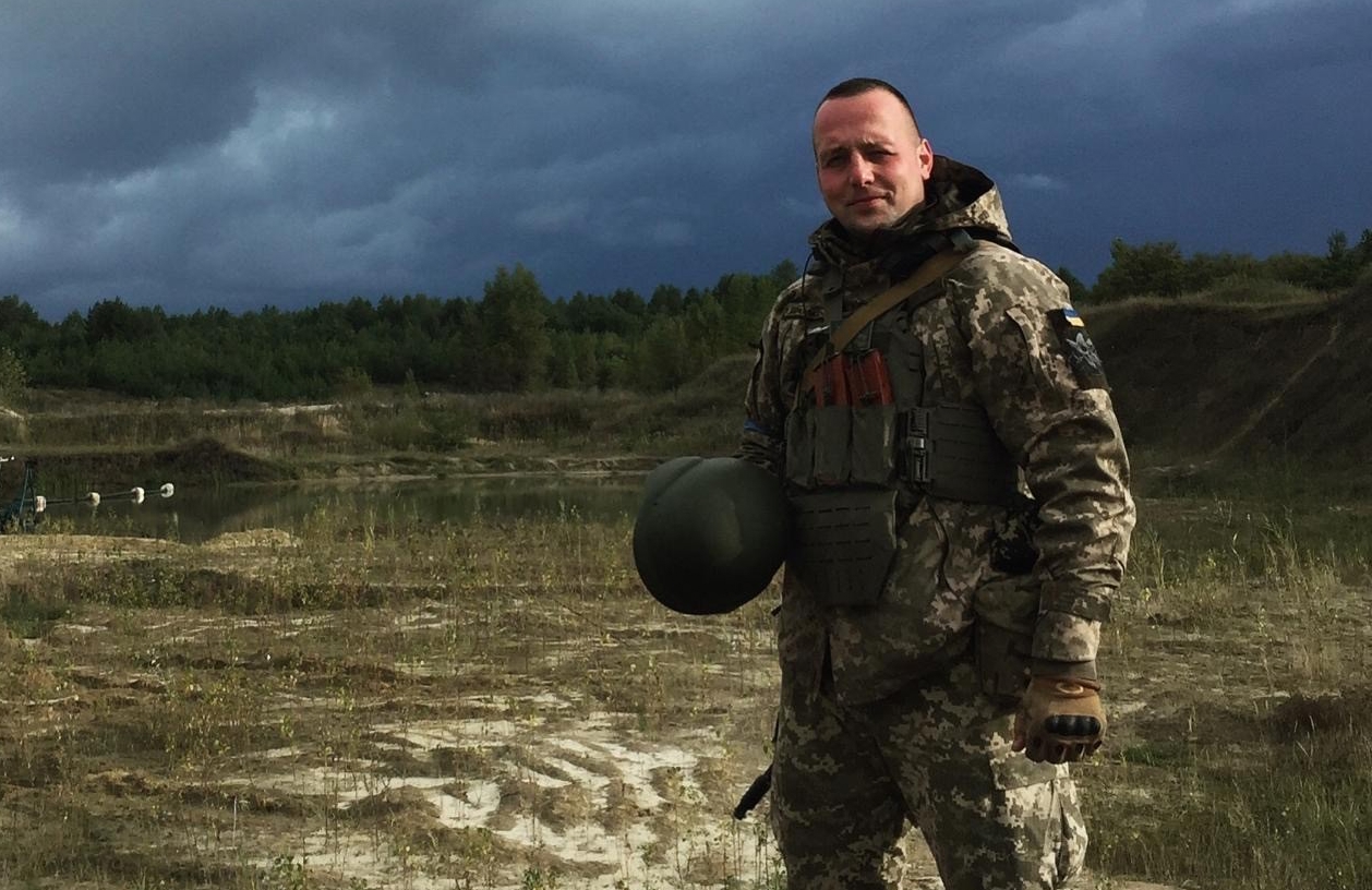 Serhii Pashkovskyi står i militært utstyr på en slette.