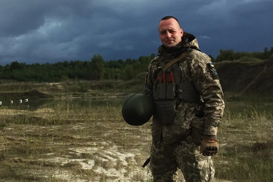 Serhii Pashkovskyi står i militært utstyr på en slette.