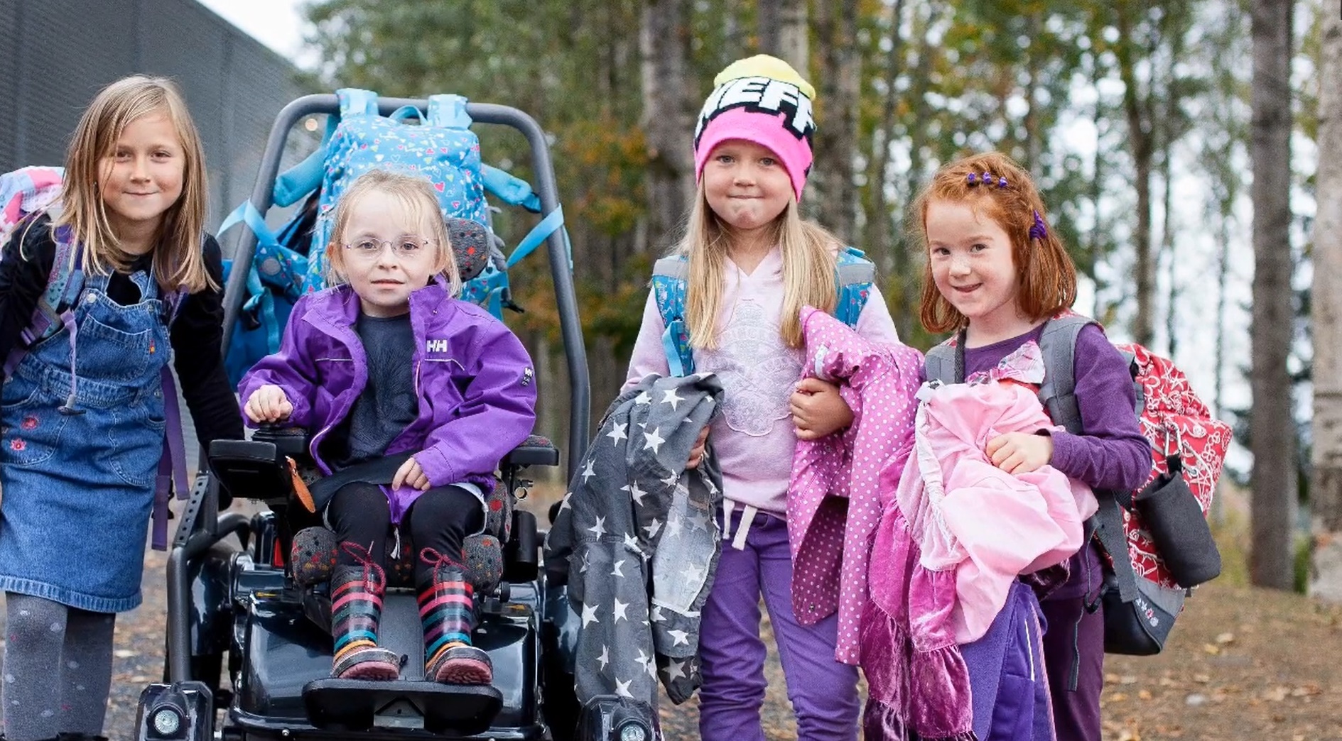 Barn på skoletur, et av de bruker elektrisk rullestol