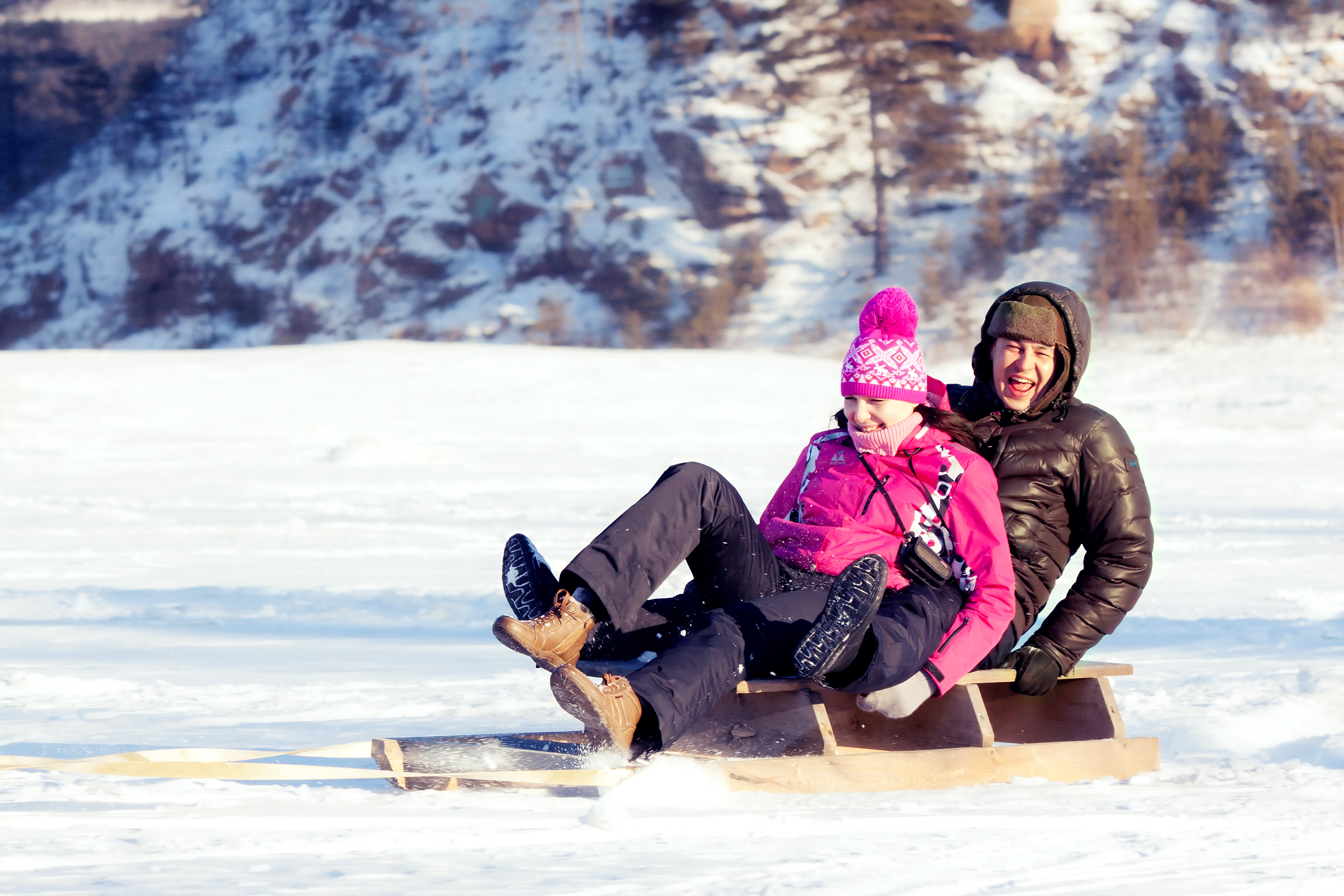 To personer som sitter på en kjelke i snøen